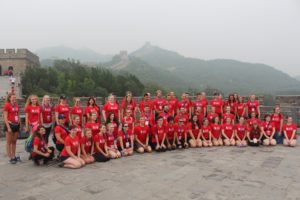 100 performers and travellers pose infront of the Great Wall of China