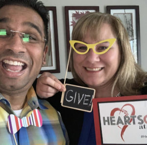 Event attendee selfie celebrating at home with photobooth props and signs